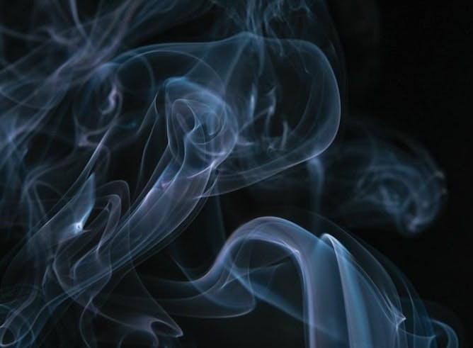 trails of smoke against a black background