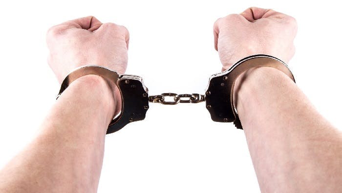 Arms outstretched with handcuffs on