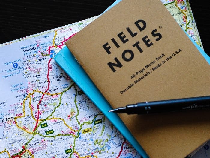 Field notes booklet with pen on top of map