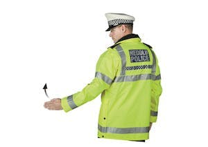 Police officer beckoning traffic on from behind using a hand signal