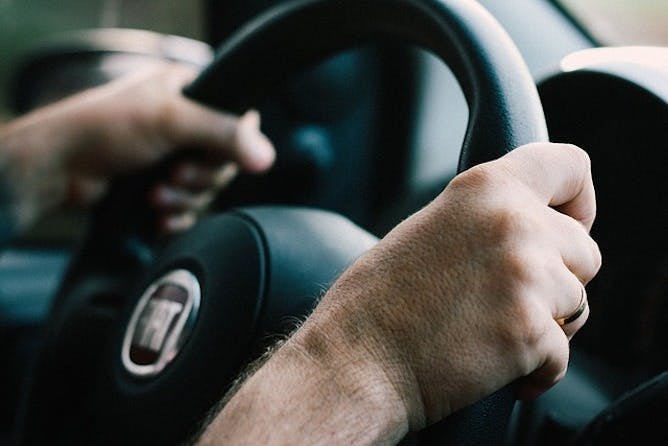 Photograph of hands holding a steering wheel