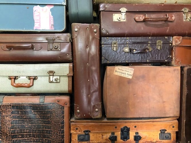 Photograph of a stack of leather suitcases piled upon each other