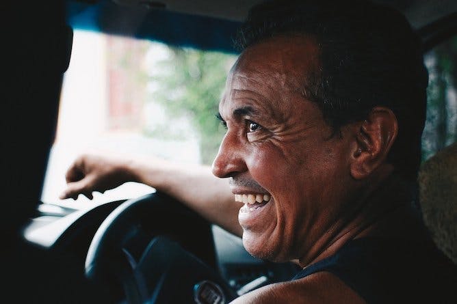 man driving a car and smiling