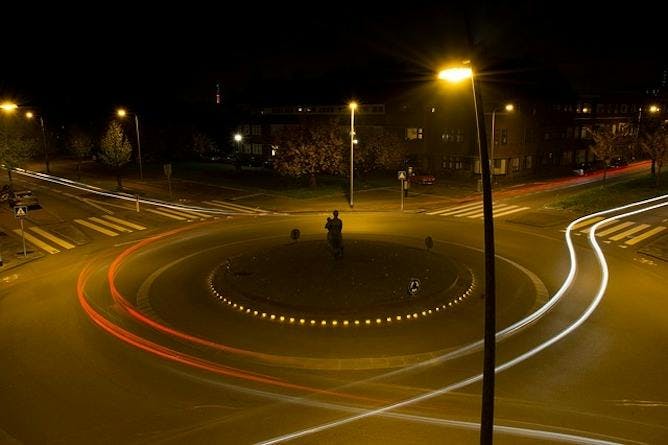 A roundabout with long exposure of headlights going around it