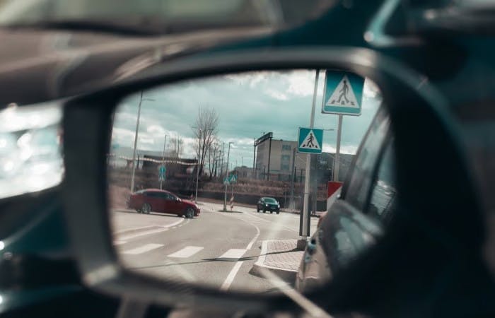 View of cars and road in side mirror