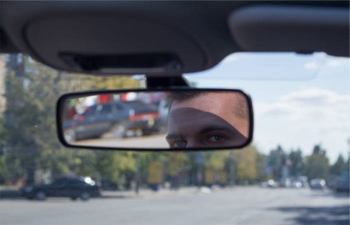 man checking his rear view mirror