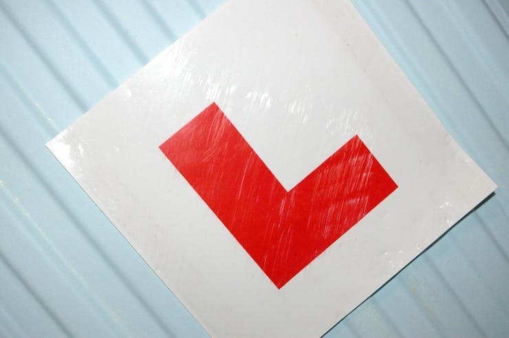 An L plate on a light blue background