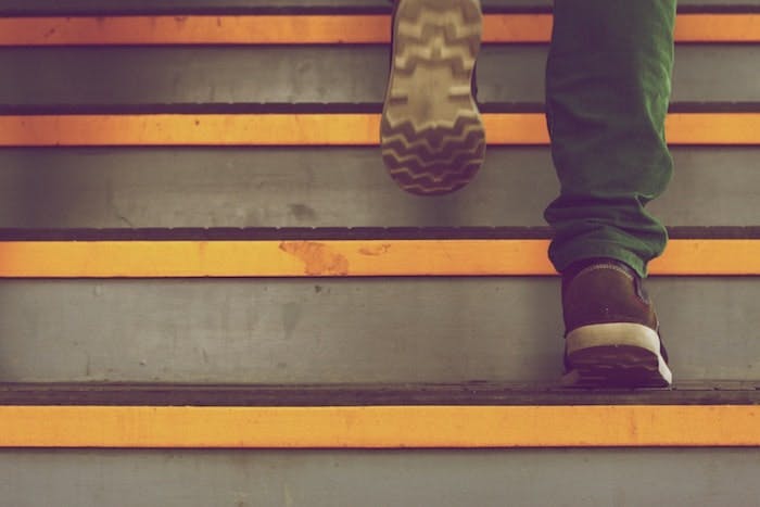 Photograph of a person's feet as they ascend a staircase