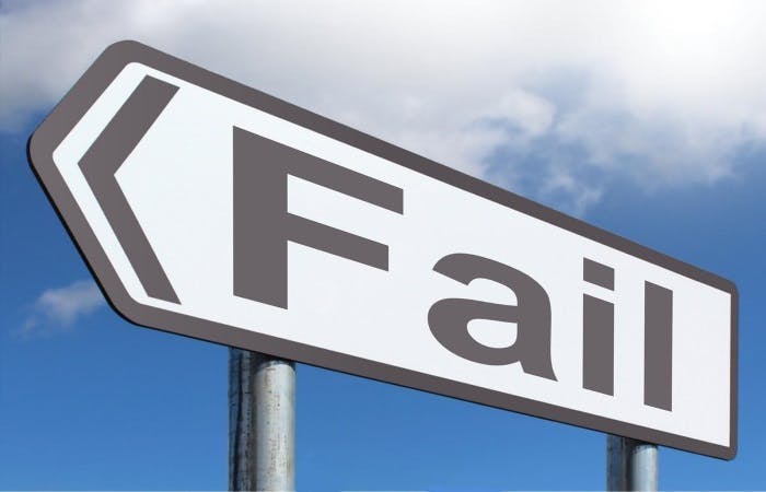 A road sign pointing left with the word 'Fail' written on it