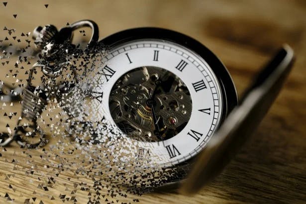 A pocket watch that is disappearing in dust