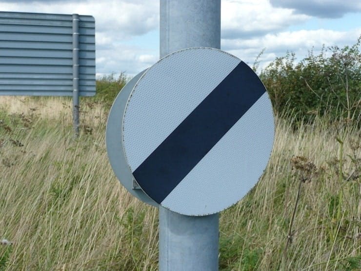 Photograph of a national speed limit sign on a post