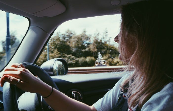 Close up picture of a woman holding a steering wheel