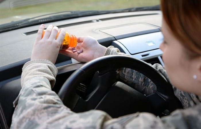 Driver emptying pills into hand