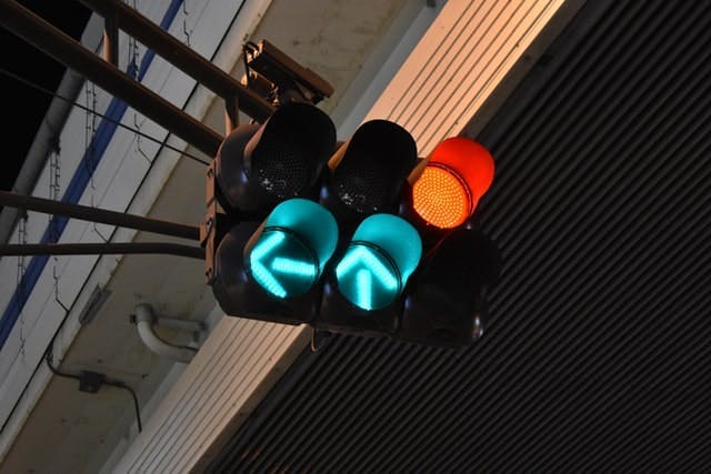 An image of a large traffic light showing two arrow lights in green and one red light 