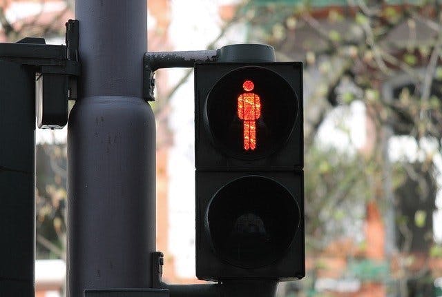 An image of a pedestrian traffic light showing a red person icon 