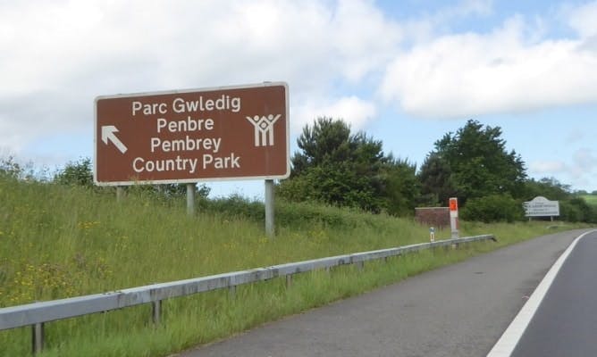 Brown tourist information sign on the M4 showing directions to Pembrey Country Park