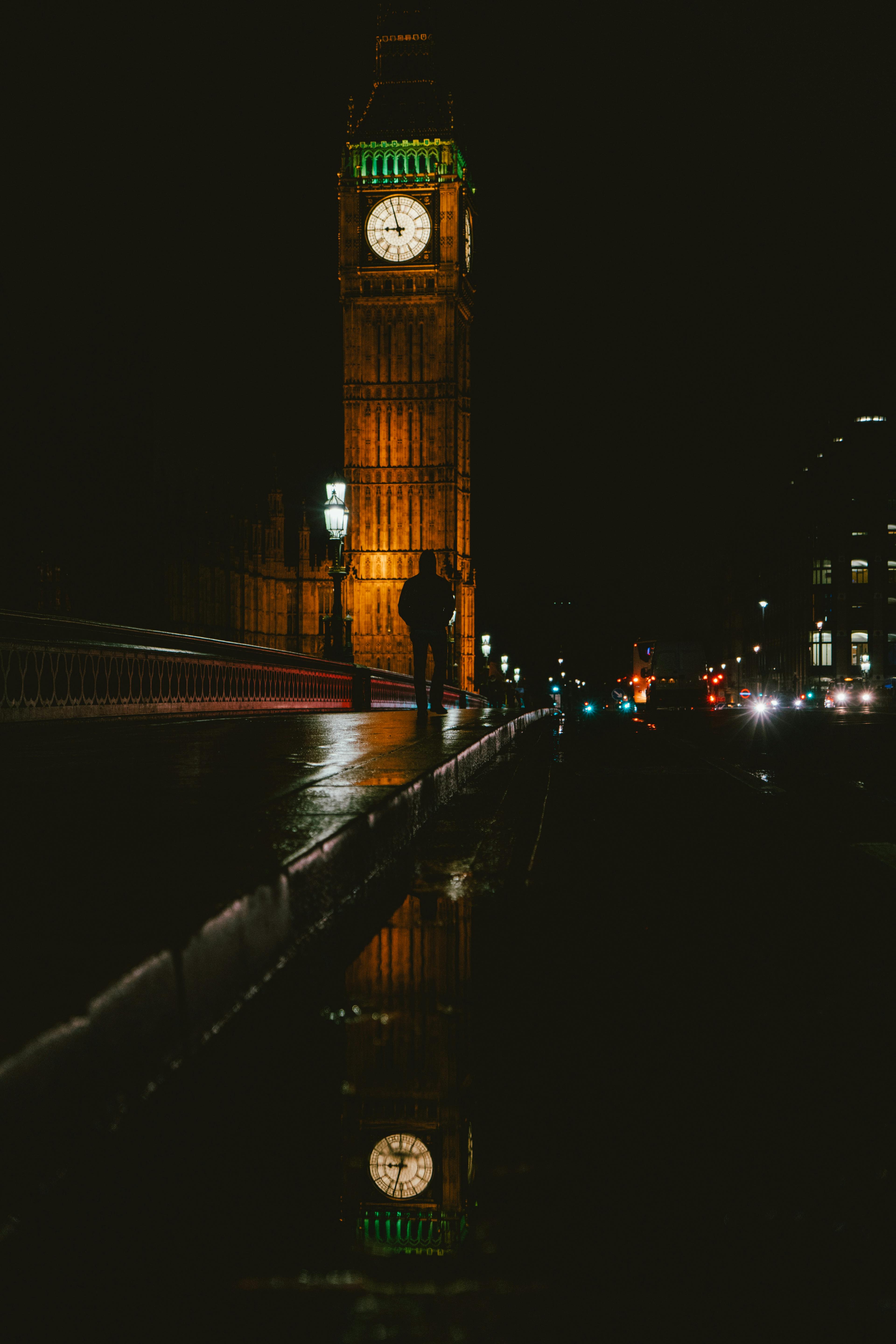 Silhouette photo of man walking near Big Ben during nighttime