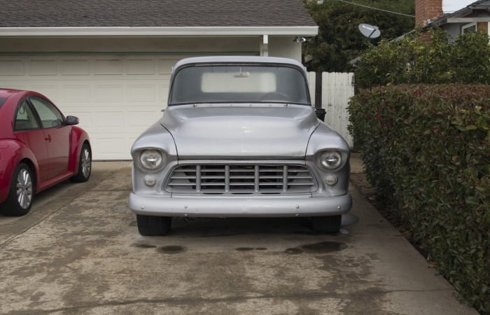 silver-vintage-car-parked-in-driveway-next-to-red-car