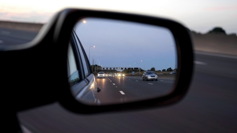 Car mirror showing a reflection of a motorway