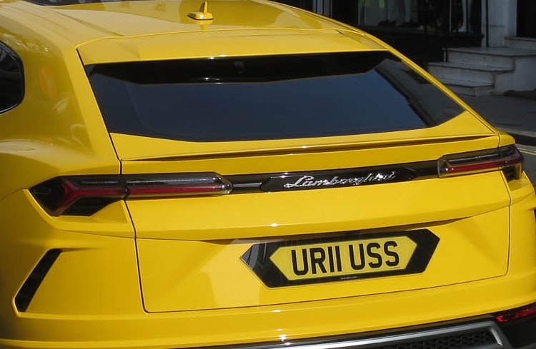 Rear of a yellow Lamborghini displaying a UK licence plate that reads "UR11 USS"