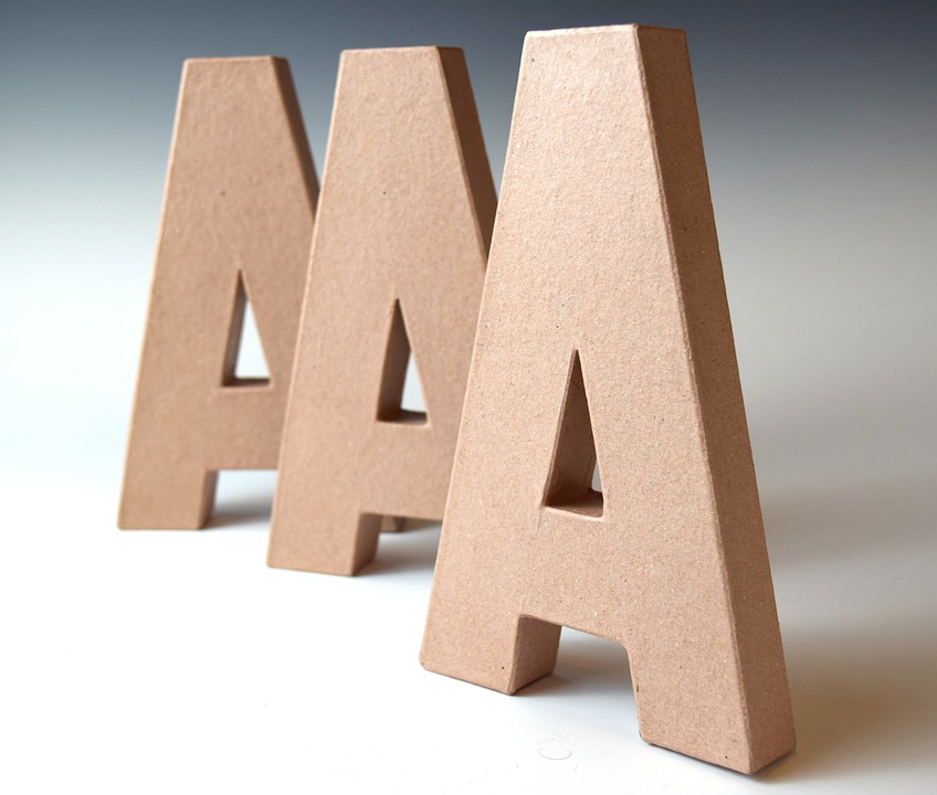 Three letter As made of wood with white background